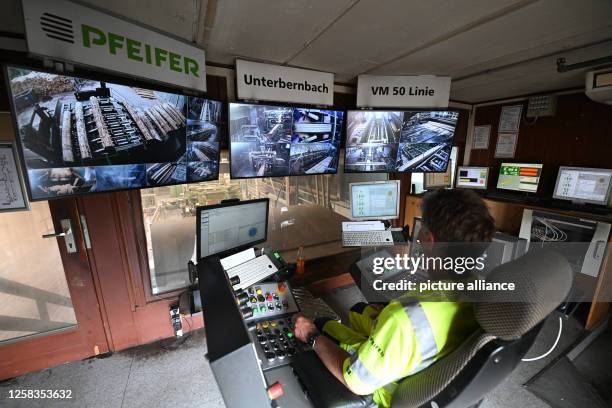 May 2023, Bavaria, Unterbernbach: An employee operates the control station in a sawmill - - taken during an excursion along the value chain of a wood...