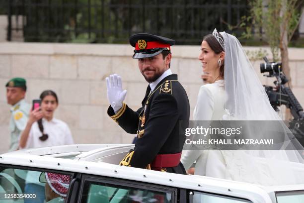 Jordan's Crown Prince Hussein and his wife Saudi Rajwa al-Seif leave in a convoy following their royal wedding ceremony in Amman on June 1, 2023. The...