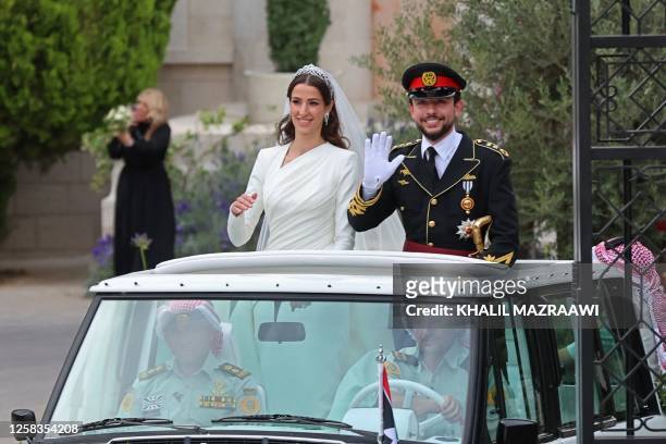Jordan's Crown Prince Hussein and his wife Saudi Rajwa al-Seif wave as they leave the Zahran Palace in Amman on June 1, 2023 following their royal...