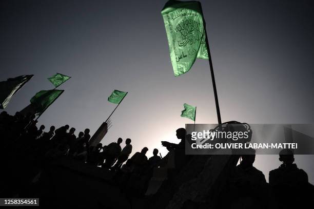 Palestinian supporters of Hamas wave the movement's flags as they demonstrate on the rubble of a house in Gaza City on January 30, 2009. Palestinian...