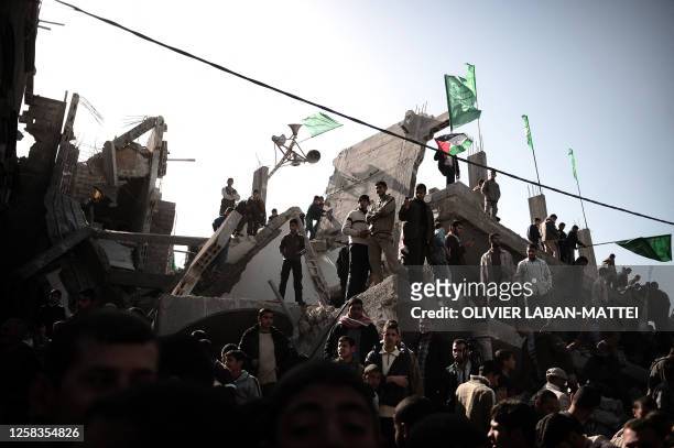 Palestinian supporters of Hamas wave the movement's flags as they demonstrate on the rubble of a house in Gaza City on January 30, 2009. Egypt is to...