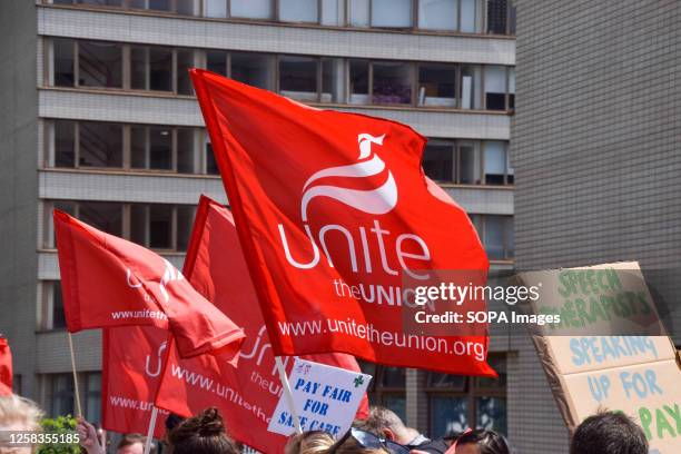 Unite union members hold union flags at the picket line outside St Thomas' Hospital as NHS workers stage a strike over pay.