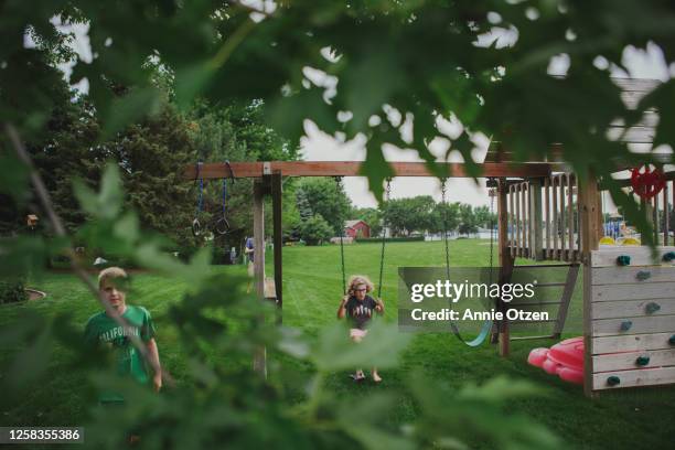kids playing on backyard swing set - backyard swing set stock pictures, royalty-free photos & images