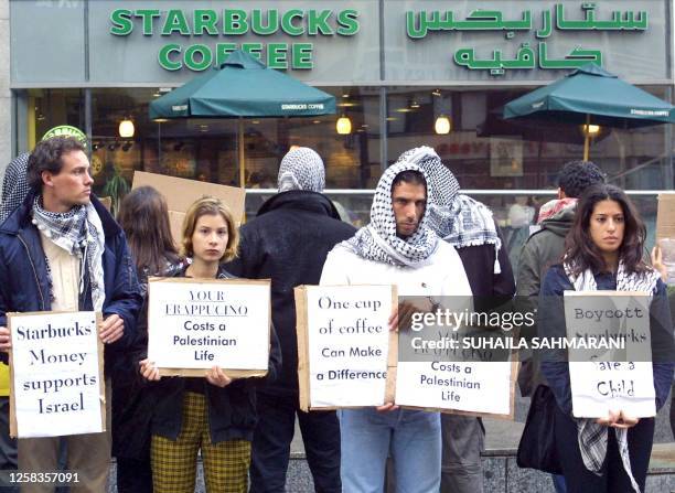 Lebanese protesters hold up placards denouncing the US coffee house chain Starbucks outside the store on Verdun street in Beirut 21 April 2002....