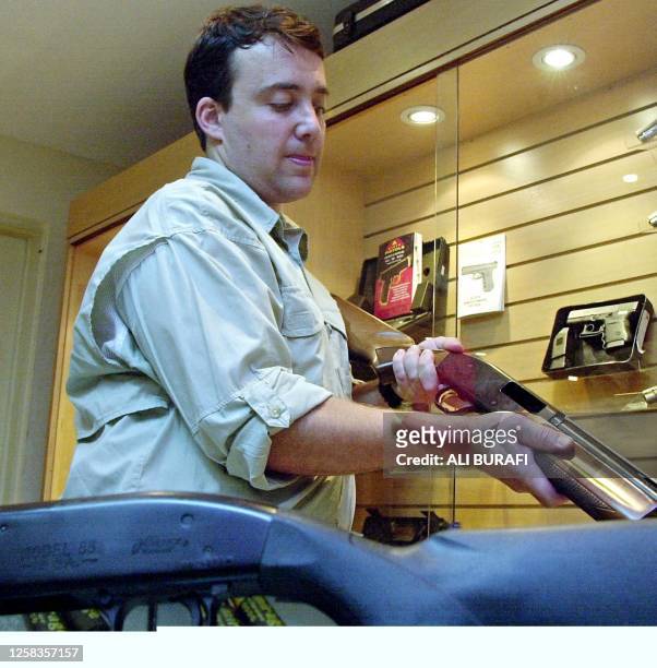 Julio Caroni, manager of a gun store, is seen with a gun, in Buenos Aires, Argentina, 24 January 2002. Julio Caroni, gerente de un local de ventas de...