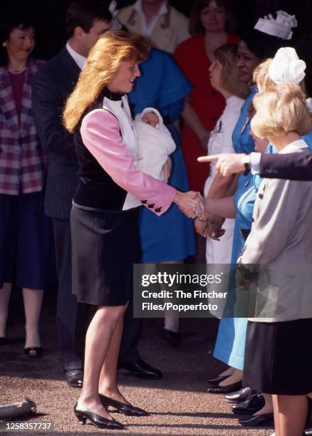 Prince Andrew with his wife Sarah The Duchess of York and new-born daughter Princess Eugenie leaving Portland Hospital in London on 30th March 1990.