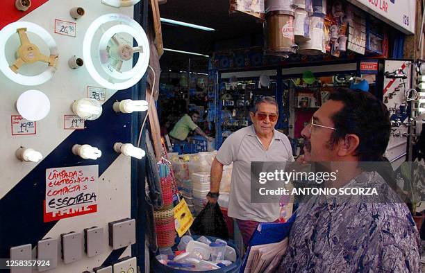 Consumer observes florescent lights outside a store, 22 May 2001, in Rio de Janeiro, Brazil. Un consumidor observa las lamparas fluorescentes...