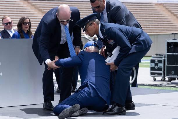 President Joe Biden is helped up after falling during the graduation ceremony at the United States Air Force Academy, just north of Colorado Springs...