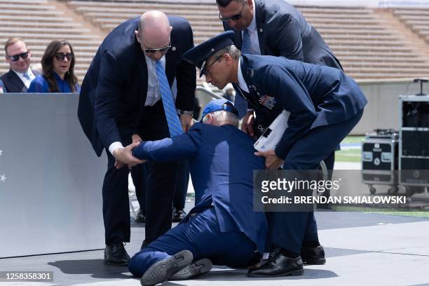 President Joe Biden is helped up after falling during the graduation ceremony at the United States Air Force Academy, just north of Colorado Springs...