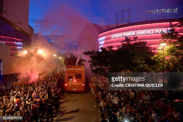 Sevilla's players and members of staff arrive at at the Ramon Sanchez Pizjuan stadium after parading with their trophy aboard a open-top bus to...