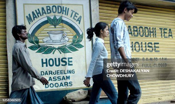Indian pedestrians walk past a closed tea leaf shop in Kolkata, 18 July 2005. A near week-long strike which has paralysed over 300 tea plantations in...