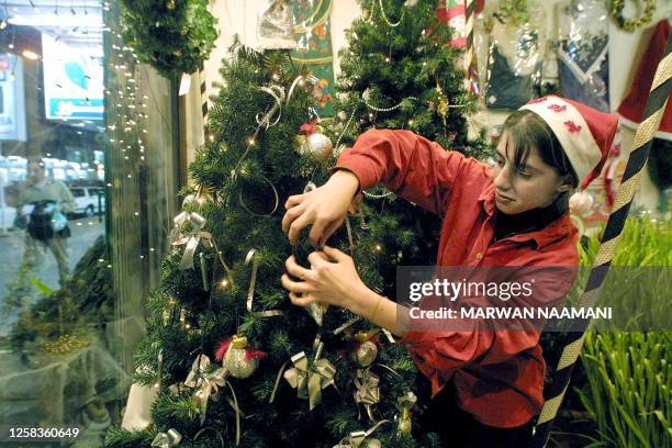 Rita, a young Iraqi Christian, decorates a Chrismas tree at her shop in Baghdad 22 December 2002. Iraq's Christian minority of about 750 000 out of a...