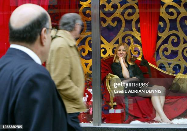 Live model in a Valentine's Day sale display watches pedestrians from an Oxford Street department store in London 12 February, 2004. AFP PHOTO/Adrian...