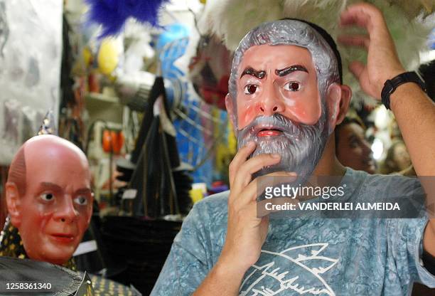 Man tries on a mask of presidential candidate of Brazil for the Worker's Party Luis Inacio Lula da Silva, in a store in Rio de Janeiro, 24 October...