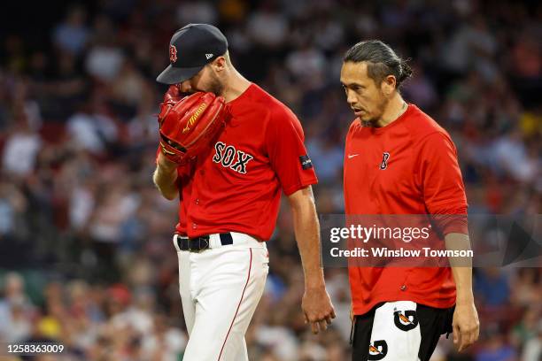 Chris Sale of the Boston Red Sox bites on his glove as he leaves the game in the middle of the fourth inning against the Cincinnati Reds at Fenway...