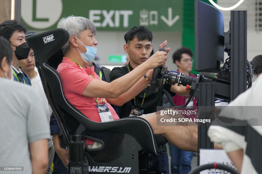 A person using a computer steering wheel at PNY booth at...