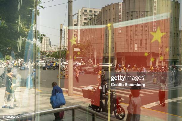 Chinese flags and pedestrians reflected in a window in Shanghai, China, on Friday, June 2, 2023. Chinese stocks staged a sharp rebound as optimism...