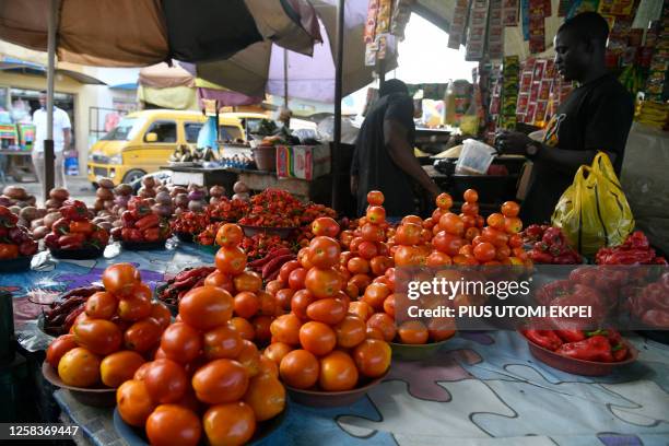 Tomatoe vendor stand beside his stock at a roadside market at Kara Isheri, Ogun State in southwest Nigeria, on June 1, 2023. Nigerian consumers are...