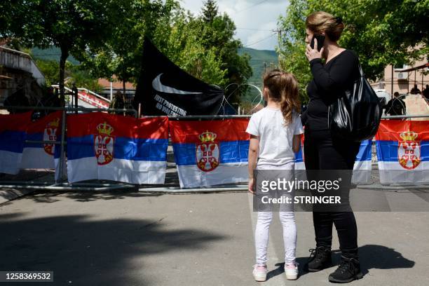 Woman with her child stands outside the Zvecan town hall in northern Kosovo on June 2 as tensions remained high after clashing with NATO-led...