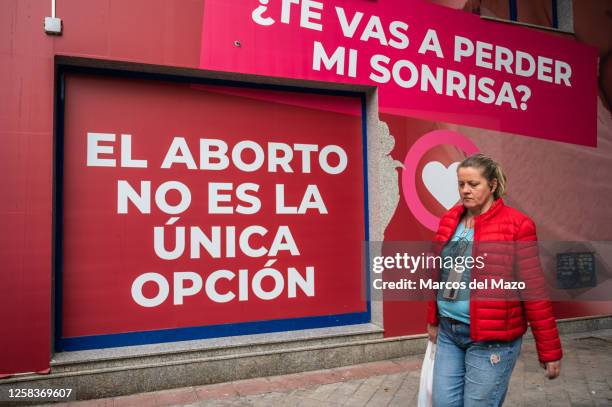 Woman walks past a sign reading "Abortion is not the only option" on the facade of the "Pro Life Shelter" in front of the Dator clinic. The Dator...