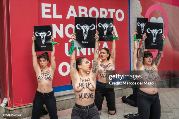 Activists of feminist group FEMEN with their bare chests painted with messages reading "You don't pray, you harass" and "abortion is sacred"...