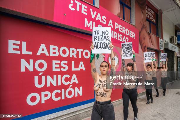 Activists of feminist group FEMEN with their bare chests painted with messages reading "You don't pray, you harass" and "abortion is sacred"...