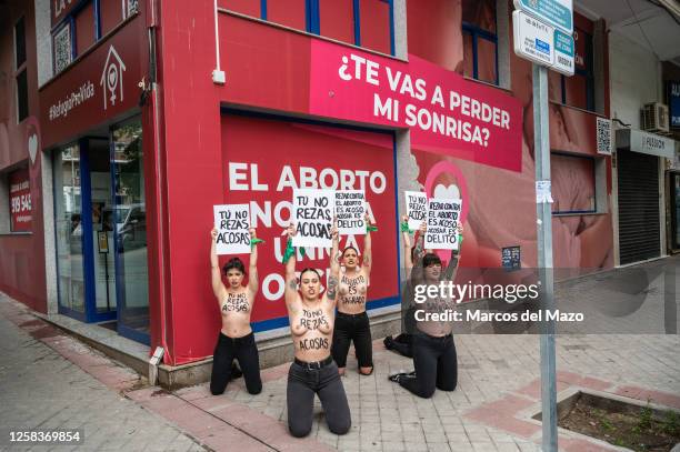 Activists of feminist group FEMEN with their bare chests painted with messages reading "You don't pray, you harass" and "abortion is sacred"...