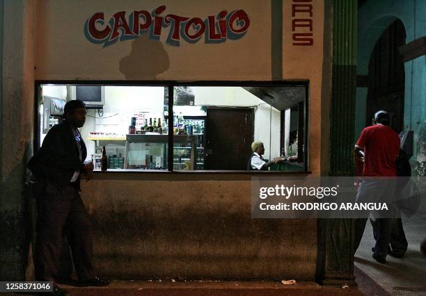 Cubans lean on the bar while drink some beer in front of the Capitol 27 November 2006 in Havana, Cuba. The military parade Saturday at which Fidel...