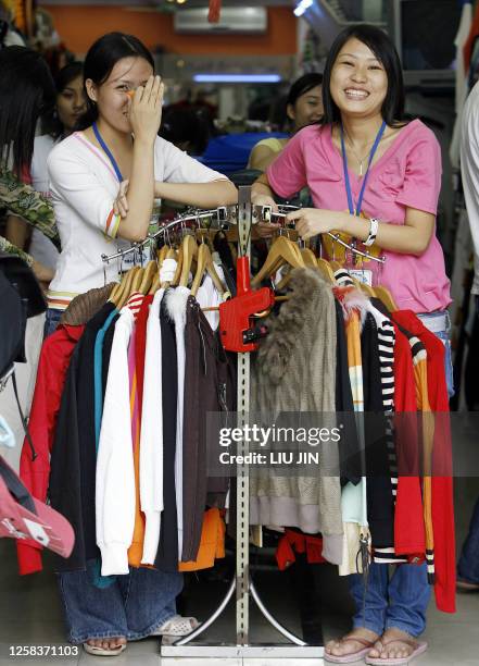 Shopkeepers smile whlie waiting for customers in Hanoi, 15 November 2006. Vietnam has gone all out to host world leaders for an Asia-Pacific summit...