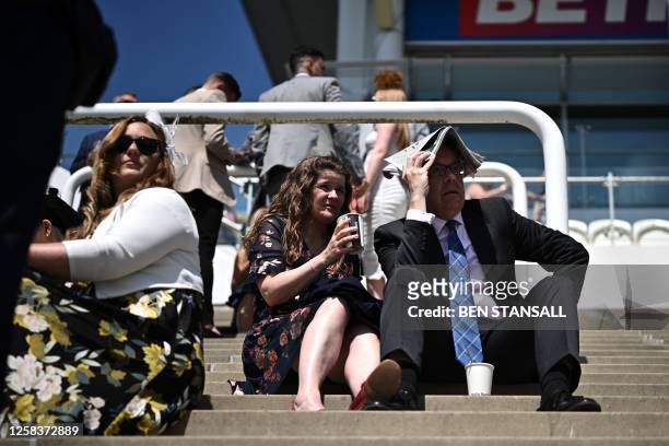 Racegoers enjoy the sunshine on the first day of the Epsom Derby Festival horse racing event in Surrey, southern England on June 2, 2023.
