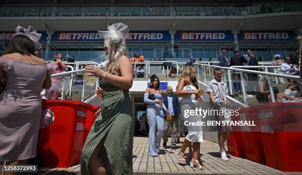 Racegoers enjoy the sunshine on the first day of the Epsom Derby Festival horse racing event in Surrey, southern England on June 2, 2023.