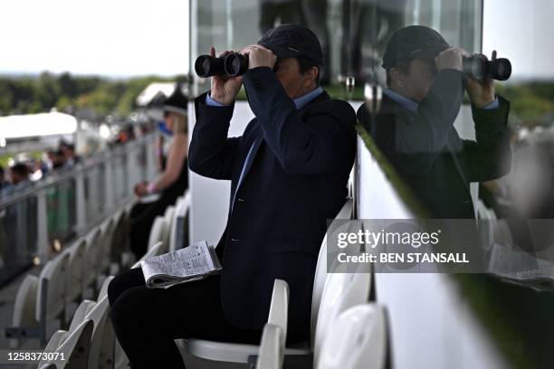 Racegoer uses binoculars ahead of racing on the first day of the Epsom Derby Festival horse racing event in Surrey, southern England on June 2, 2023.