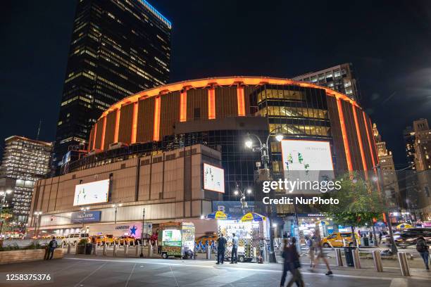 Night street view with illuminated buildings and lights of Madison Square Garden MSG, a multipurpose sports and concert arena located above metro...