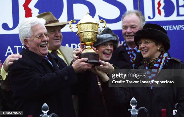 Tim Watts of Pertemps presenting the trophy to owner Jim Lewis, and his wife Valerie for winning the King George VI Chase with Edredon Bleu at...