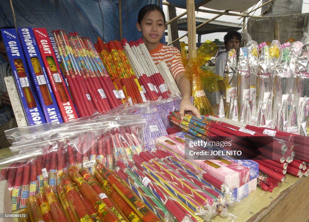 Firecracker Ph A sales girl piles stacks of skyrockets and other firecrackers for ...