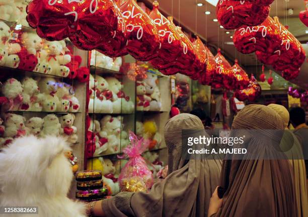 Veiled Pakistani women choose Valentine's Day gifts at a shop in Peshawar on February 11, 2011. A number of shopping centers in Pakistan are full of...