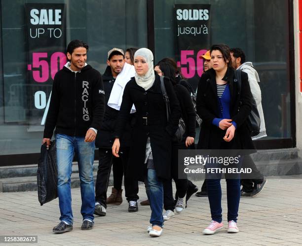 Tunisians walk past a shopping centre in the center of Tunis on February, 2 2011. Tunisia's interim government moved to take back control of the...