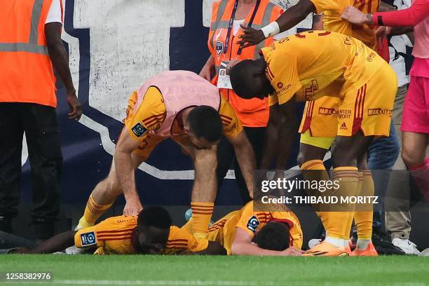 Rodez' French midfielder Lucas Buades lies on the ground after being hit by a projectile during the French L2 football match between FC Girondins de...