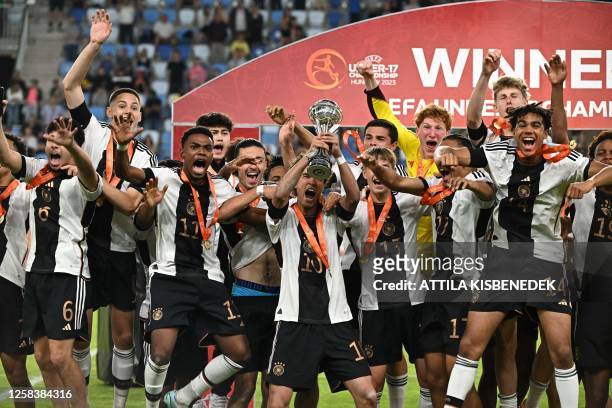 Germany's midfielder Noah Darvich and his teammates celebrate with the trophy after winning the UEFA Under 17 final football match between Germany...