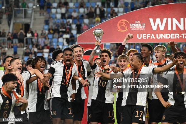 Germany's midfielder Noah Darvich and his teammates celebrate with the trophy after winning the UEFA Under 17 final football match between Germany...