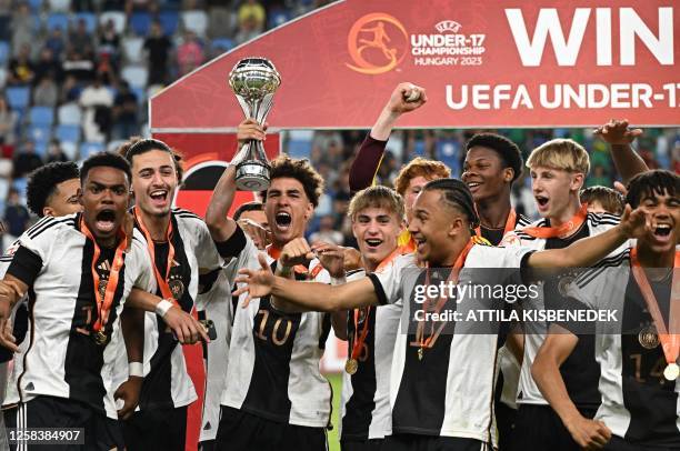 Germany's midfielder Noah Darvich and his teammates celebrate with the trophy after winning the UEFA Under 17 final football match between Germany...