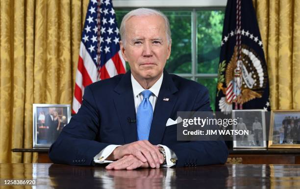 President Joe Biden sits at his desk ahead of addressing the nation on averting default and the Bipartisan Budget Agreement, in the Oval Office of...