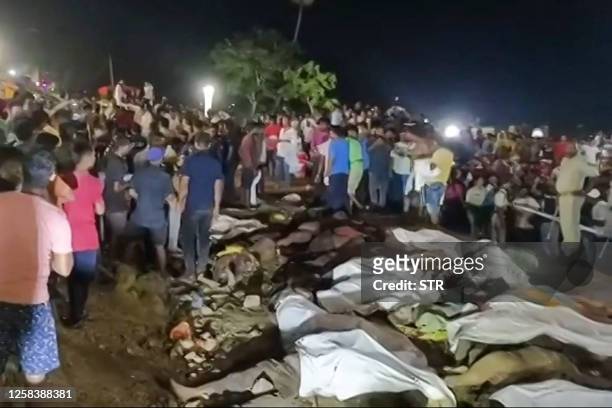 This frame grab taken from an AFPTV video footage on June 2, 2023 shows scores of bodies laid out under white sheets beside the tracks after a...