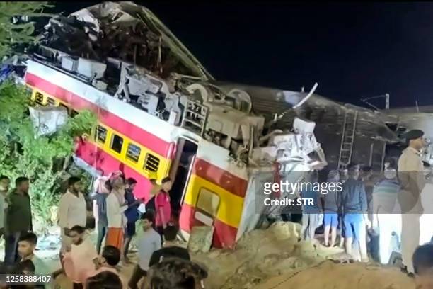 This frame grab taken from AFPTV video footage on June 2, 2023 shows flipped over train carriages after a three-train collision near Balasore, about...