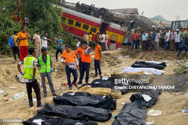 Graphic content / Medical workers stand in front of the bodies of victims killed in an accident after a three-train collision near Balasore, about...