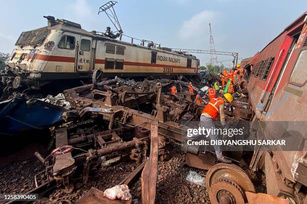 Rescue workers sift through wreckage at the accident site of a three-train collision near Balasore, about 200 km from the state capital Bhubaneswar,...