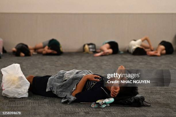 People rest inside a room in a shopping mall set aside for those wanting to escape high outdoor temperatures in Hanoi on June 3, 2023. Parts of...
