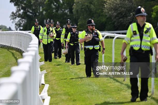 Police officers take up positions out on the course ahead of racing on the second day of the Epsom Derby Festival horse racing event in Surrey,...