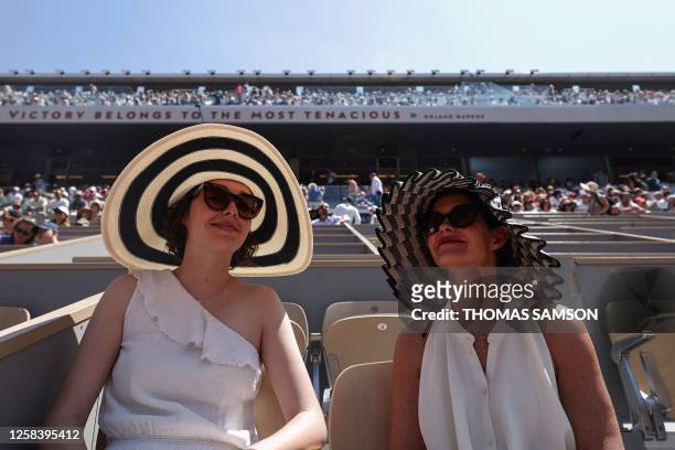 Spectators wearing hats watch the men's singles match between Denmark's Holger Rune and Argentina's Genaro Alberto Olivier on day seven of the...