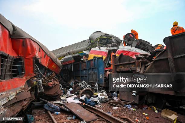Graphic content / Rescue workers recover victims' bodies from a carriage wreckage of a three-train collision near Balasore, in India's eastern state...